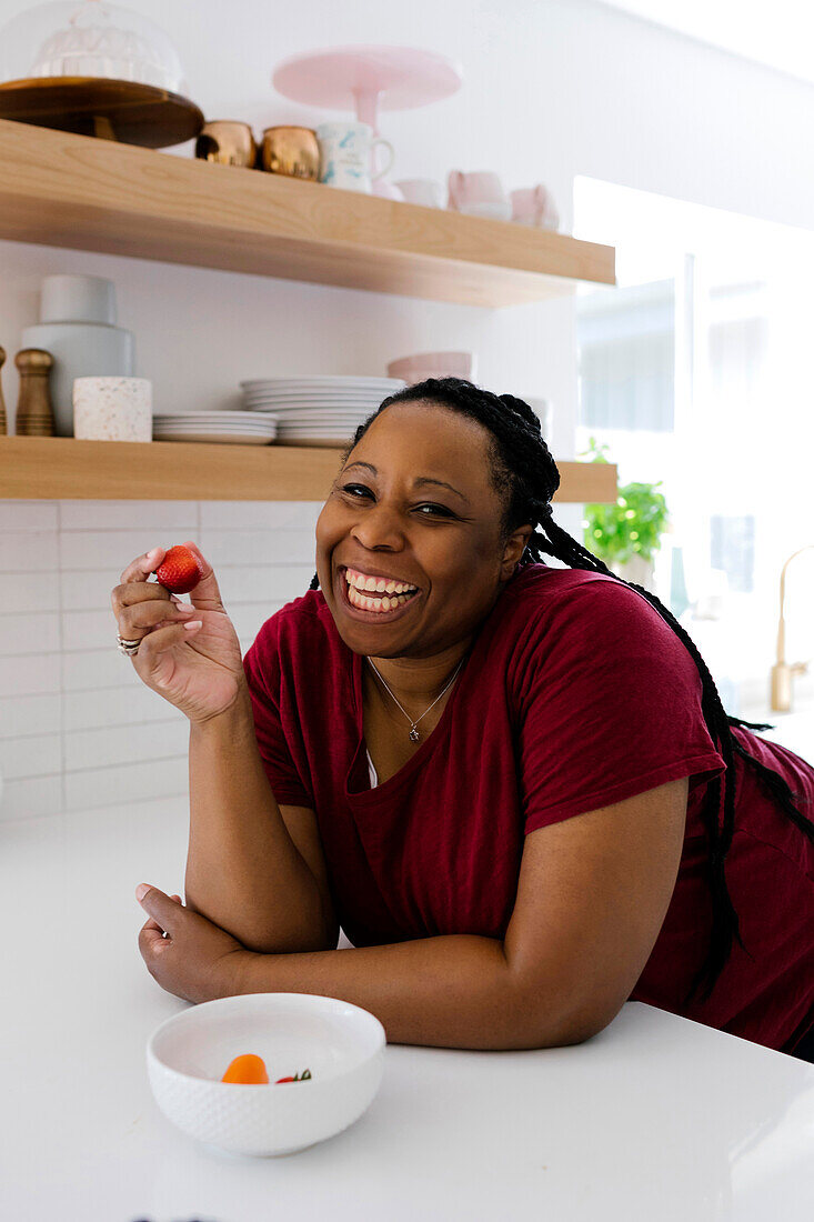Smiling woman eating red peppers