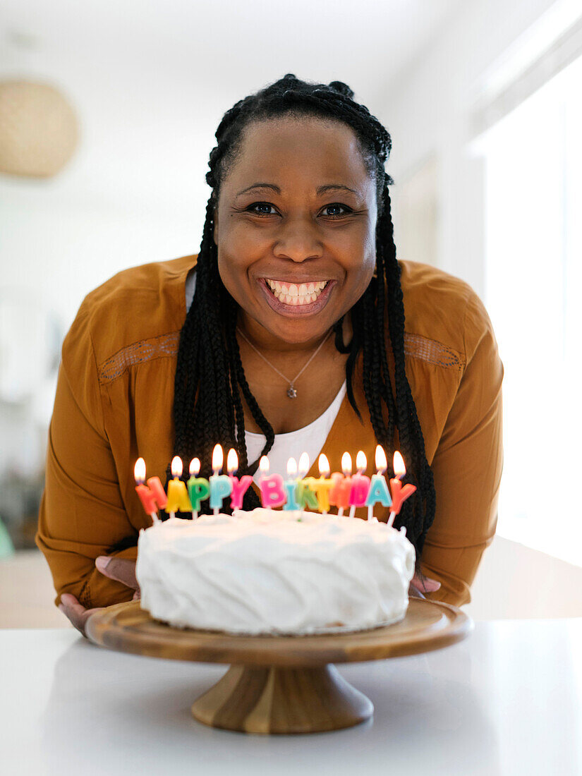 Lächelnde Frau mit Geburtstagskuchen