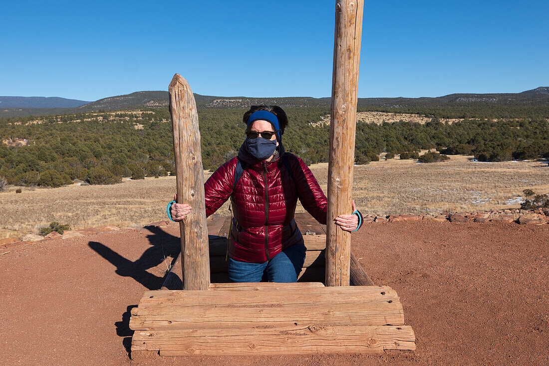 USA, New Mexico, Pecos, Woman in face mask climbing out of storage shelter at Pecos National Historical Park