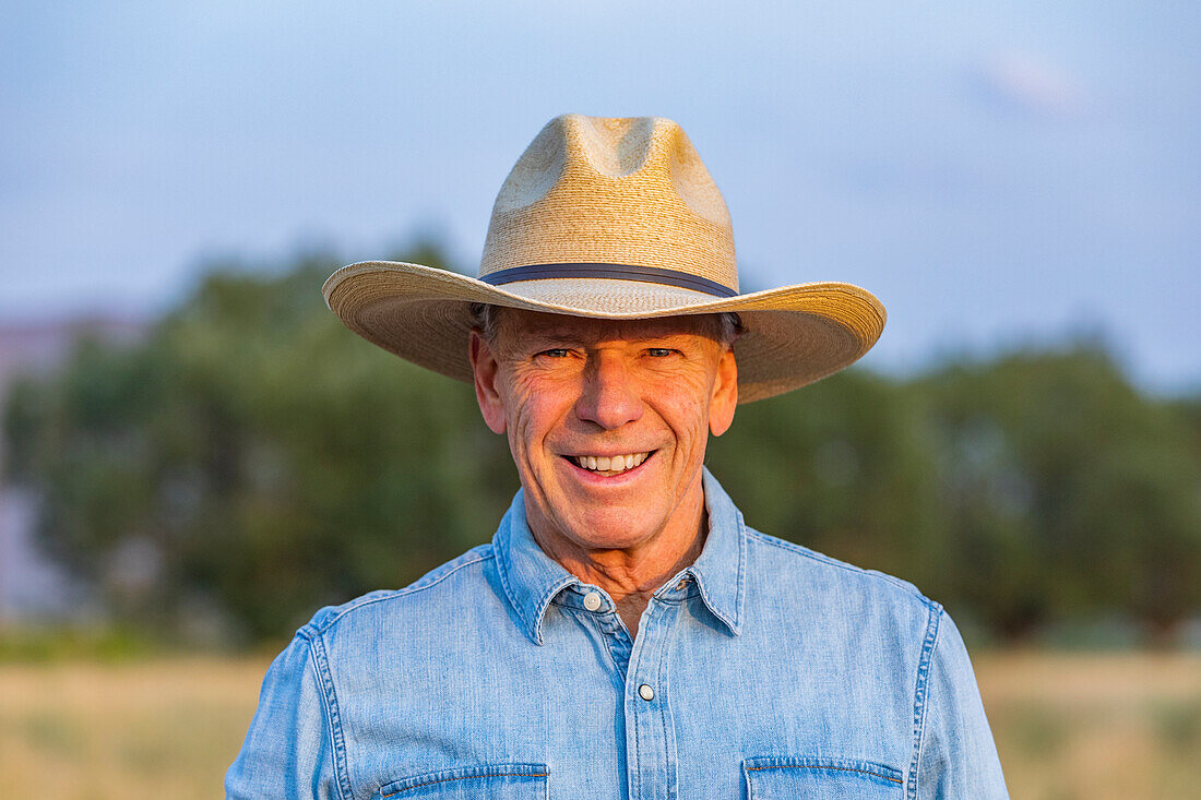 Portrait of senior man in denim shirt and cowboy hat