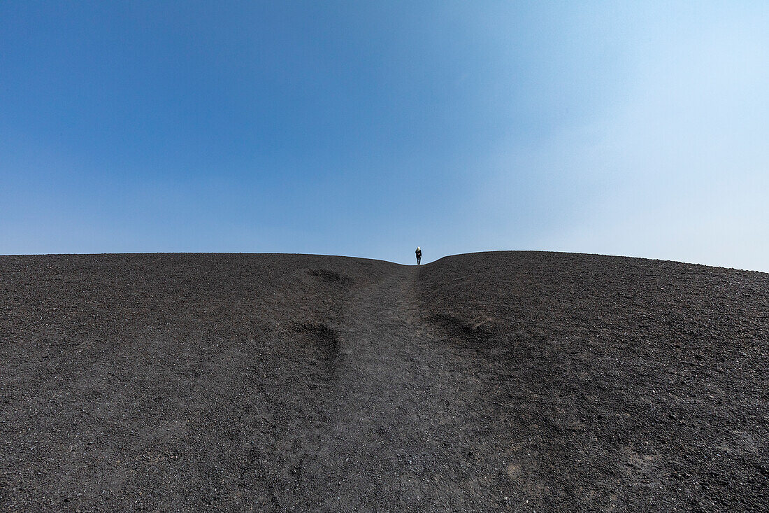 Frau wandert in einem Schlackenkegel im Craters of the Moon National Monument