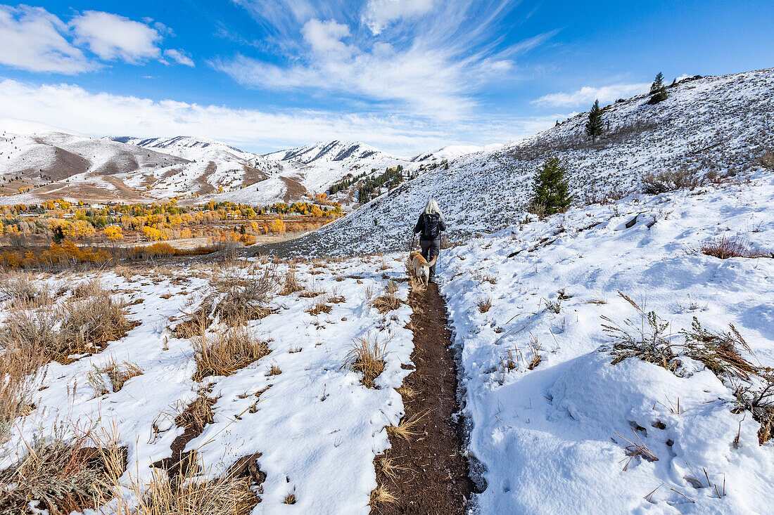 USA, Idaho, Ketchum, Hiker with golden labrador on snowy trail near Sun Valley