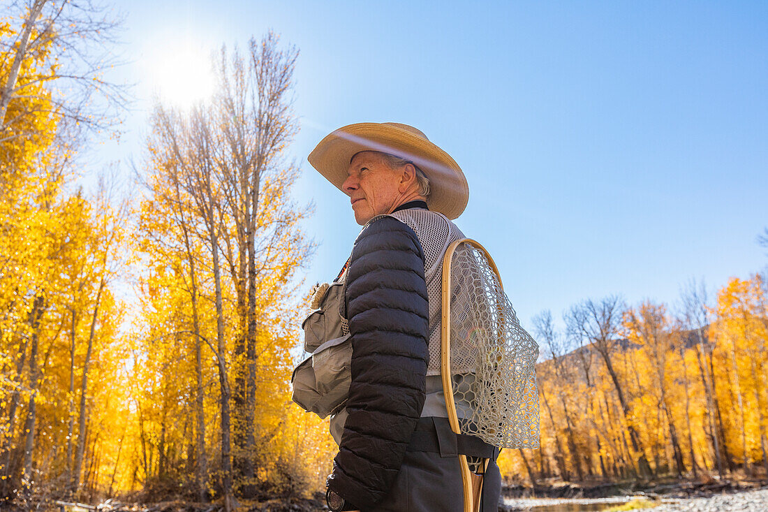 USA, Idaho, Bellevue, Senior fisherman in Autumn landscape