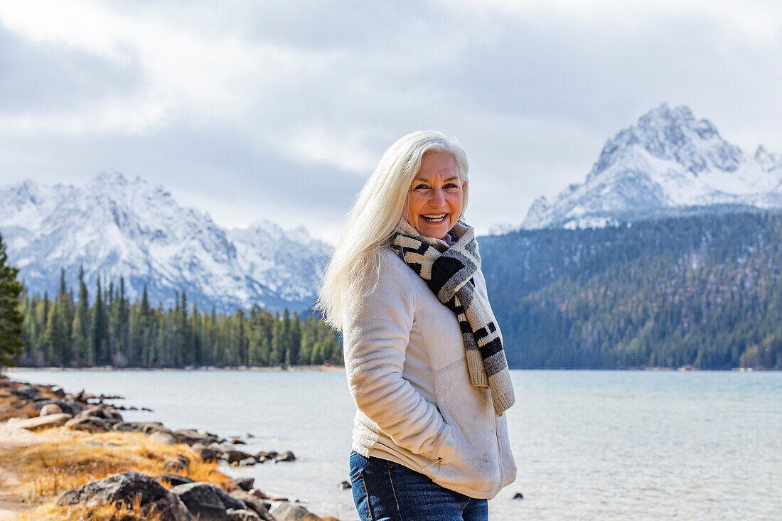 USA, Idaho, Stanley, Portrait of smiling senior woman at mountain lake