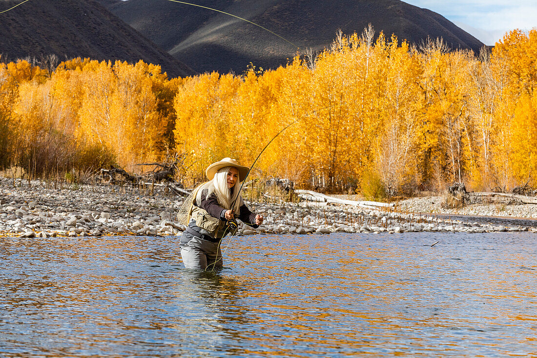 USA, Idaho, Bellevue, Ältere Frau beim Fliegenfischen im Big Wood River im Herbst