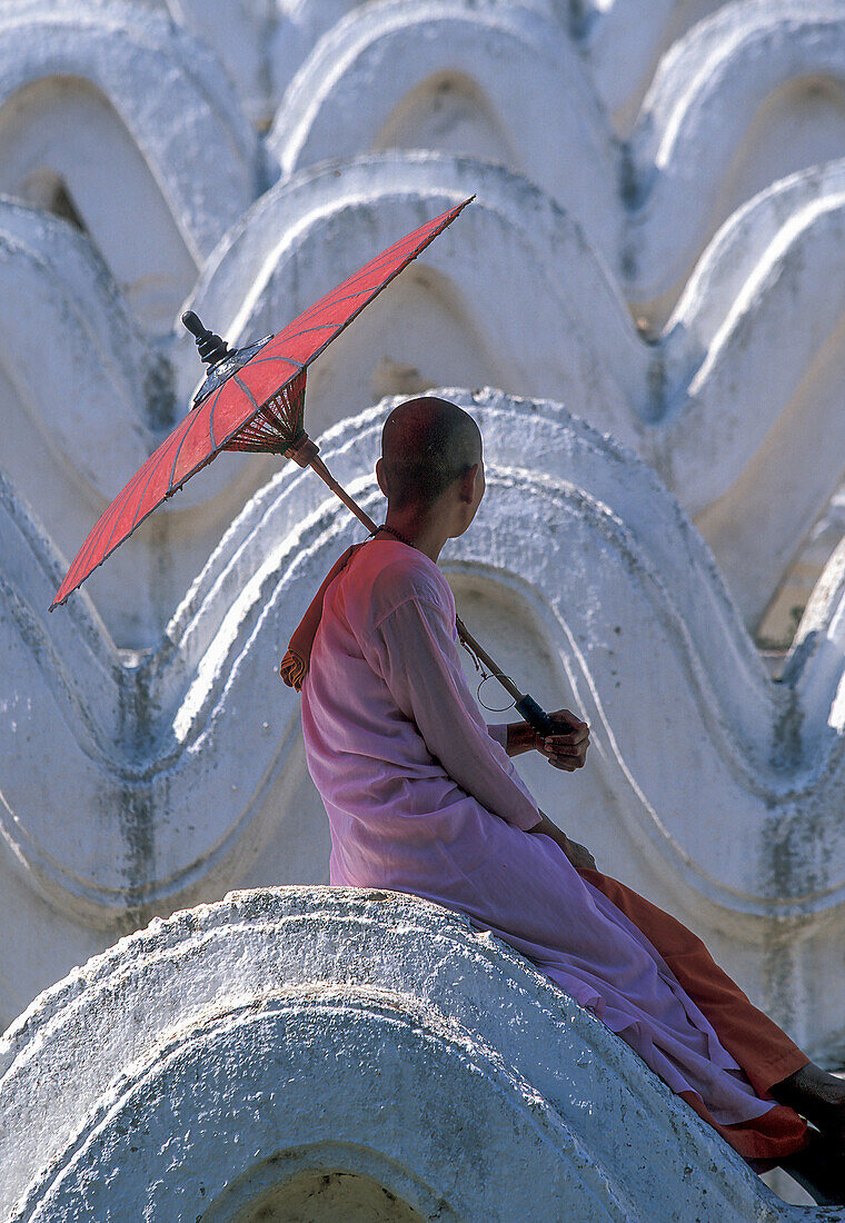 Myanmar, Mingun, Mandalay Division, Buddhist nun sitting on white arches of Hsinbyume Pagoda