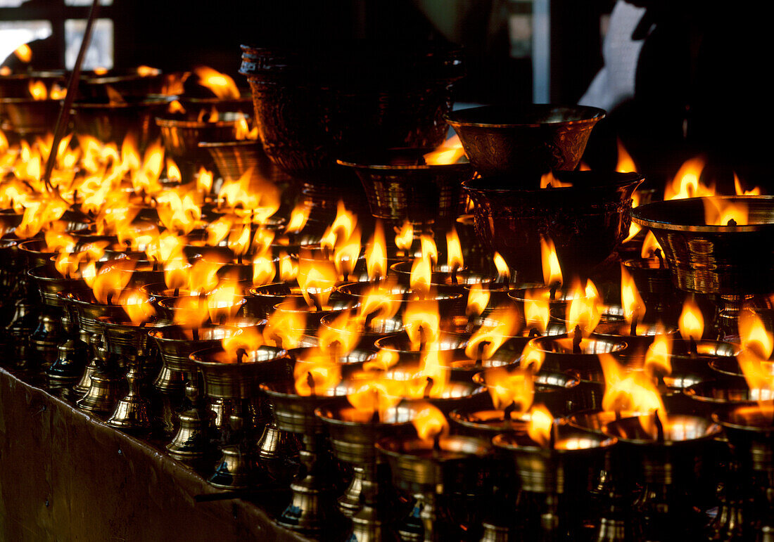 China, Tibet, Lhasa, Brennende Kerzen in einem tibetischen buddhistischen Tempel