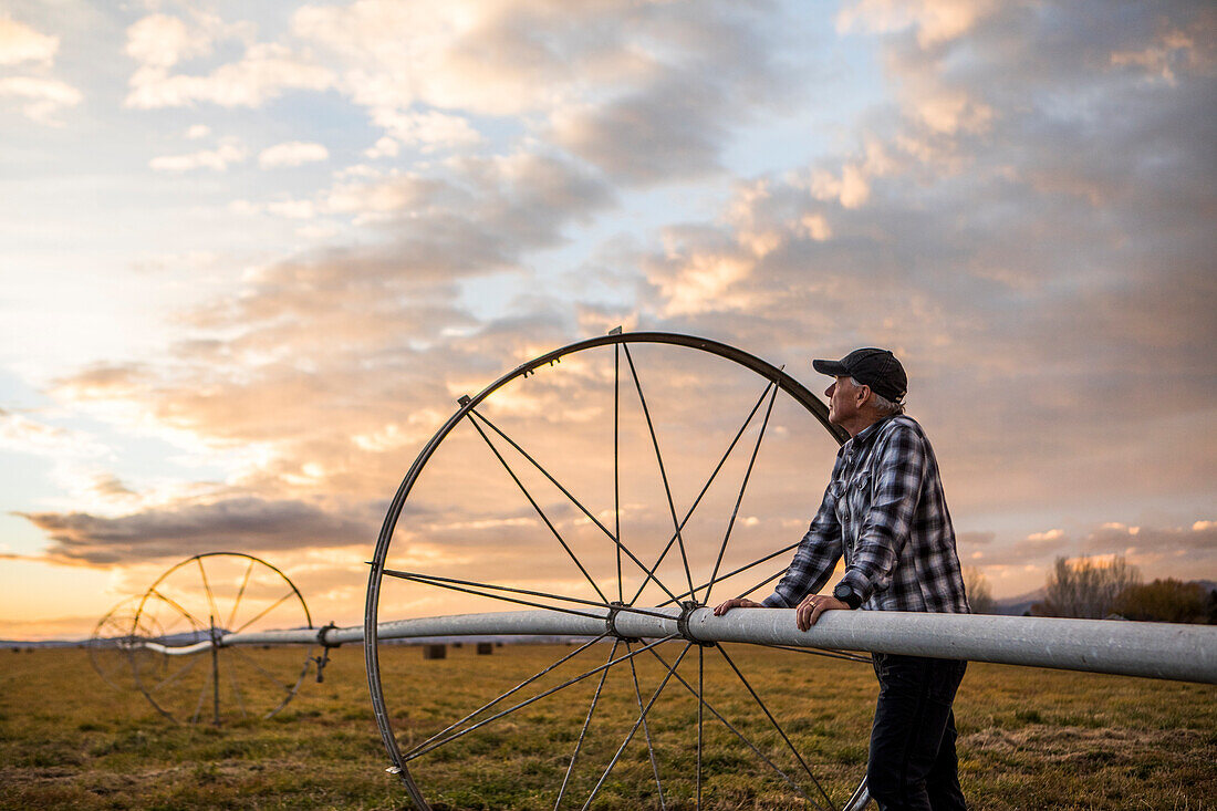 Älterer Mann bei landwirtschaftlicher Beregnungsanlage