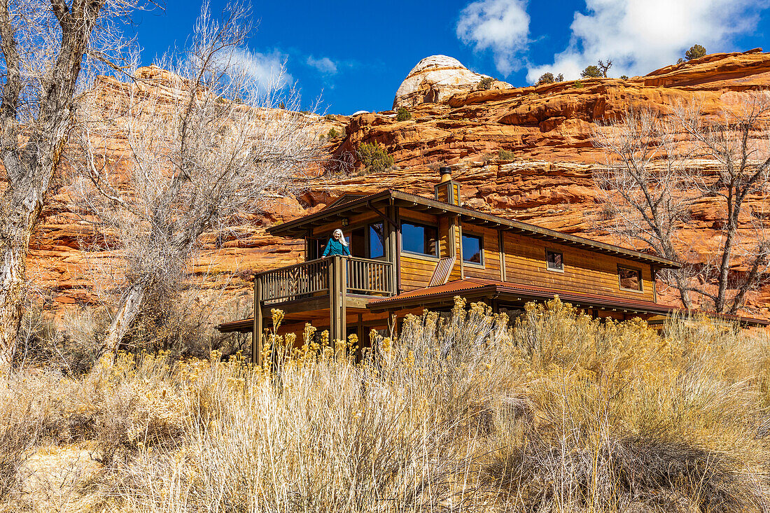 USA, Utah, Escalante, Woman on deck of home in canyon in Grand Staircase-Escalante National Monument