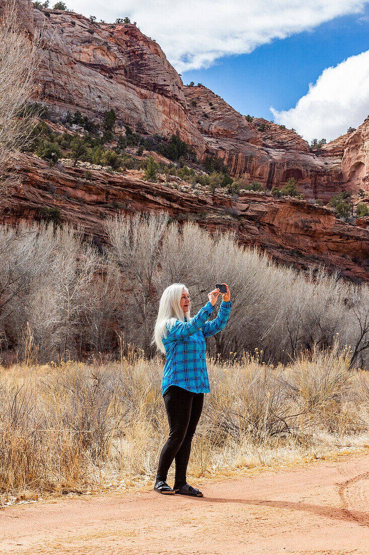 USA, Utah, Escalante, Frau beim Fotografieren während einer Wanderung im Grand Staircase-Escalante National Monument