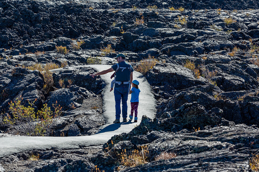USA, Idaho, Arco, Father showing daughter (6-7) lava field 