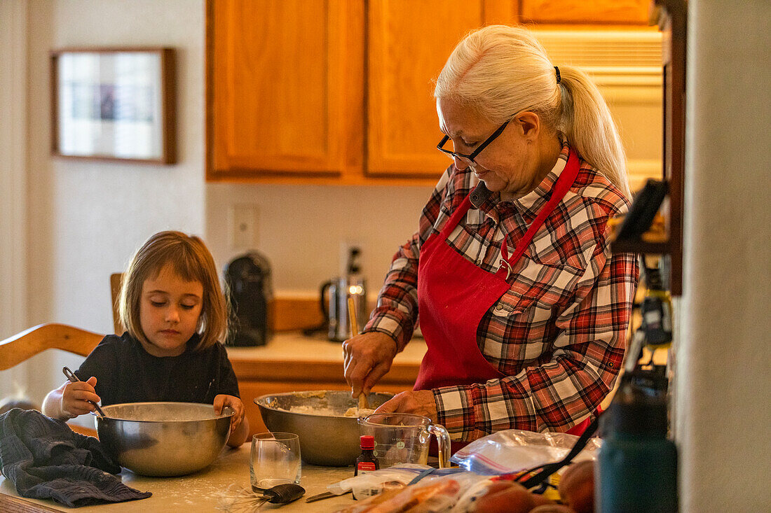 Grandmother and granddaughter (6-7) bake cookies together 