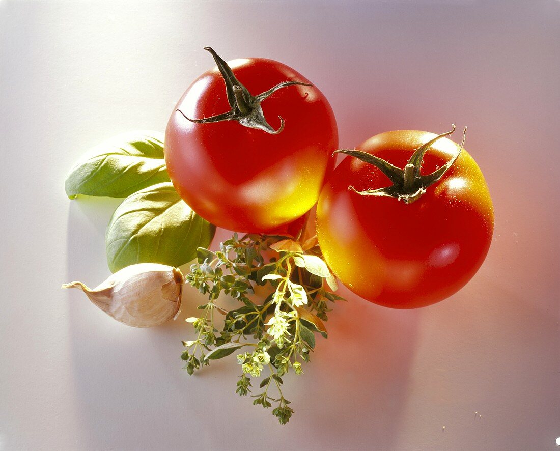 Zwei Tomaten, Basilikum, Knoblauchzehe & Oregano