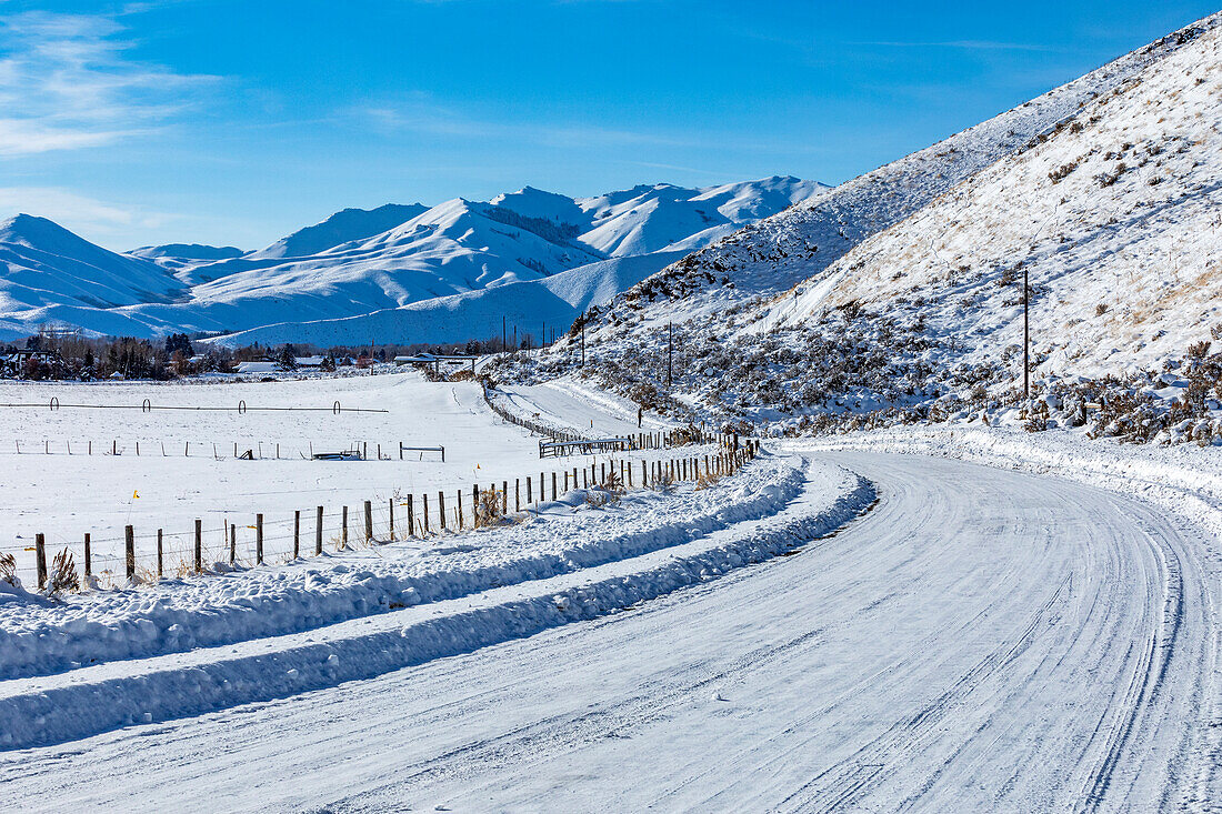 United States, Idaho, Bellevue, Snow covered rural road with mountains in distance