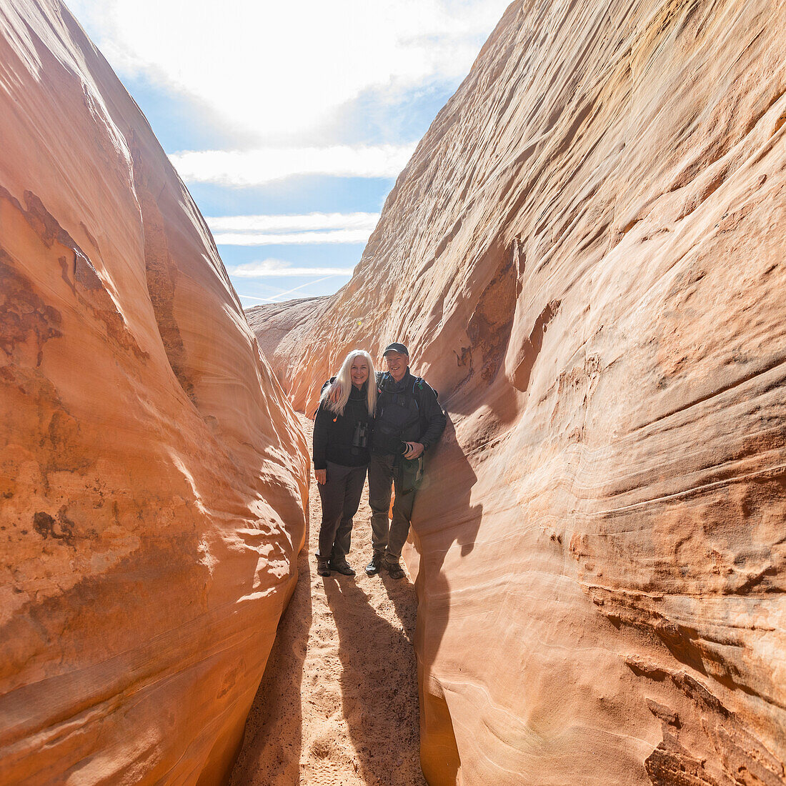 United States, Utah, Escalante, Senior hiker couple exploring slot canyon