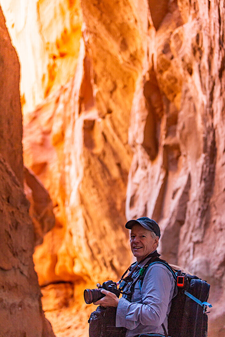 Vereinigte Staaten, Utah, Escalante, Älterer Wanderer erkundet und fotografiert Felsformationen im Kodachrome Basin State Park in der Nähe des Escalante Grand Staircase National Monument