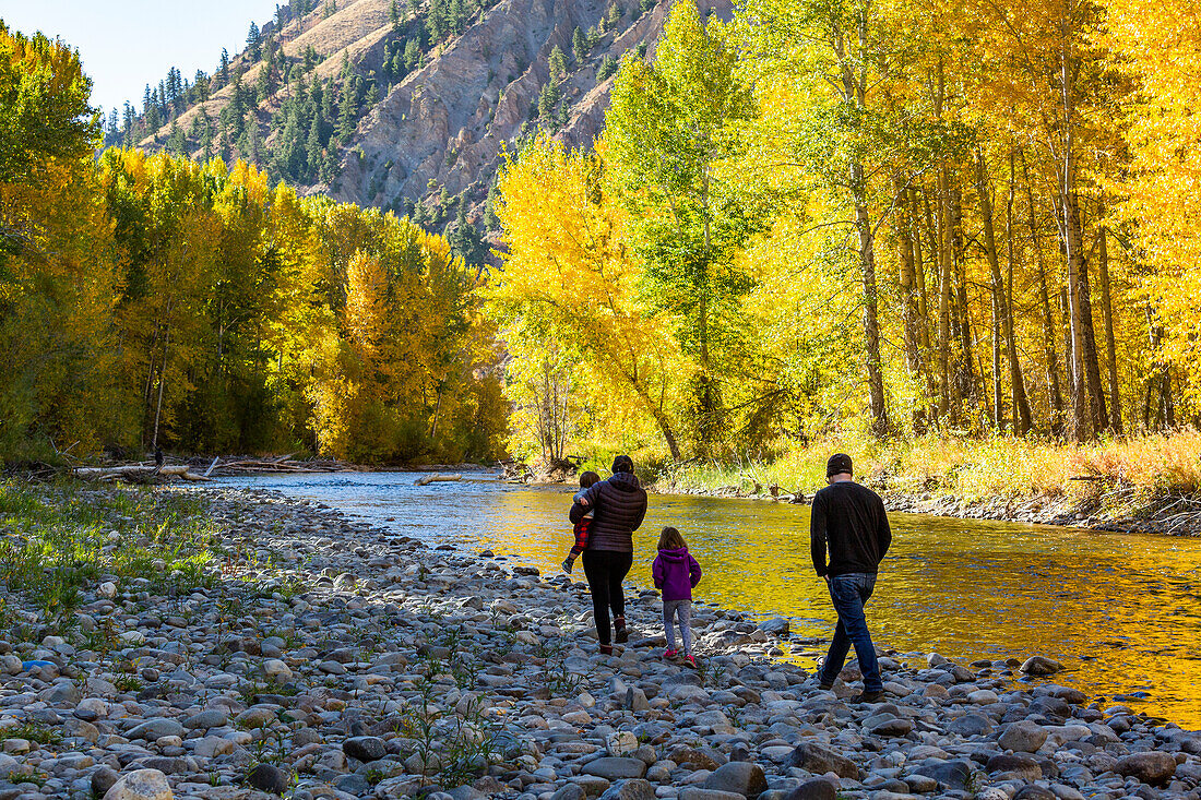 USA, Idaho, Hailey, Family admires fall along river in autumn 