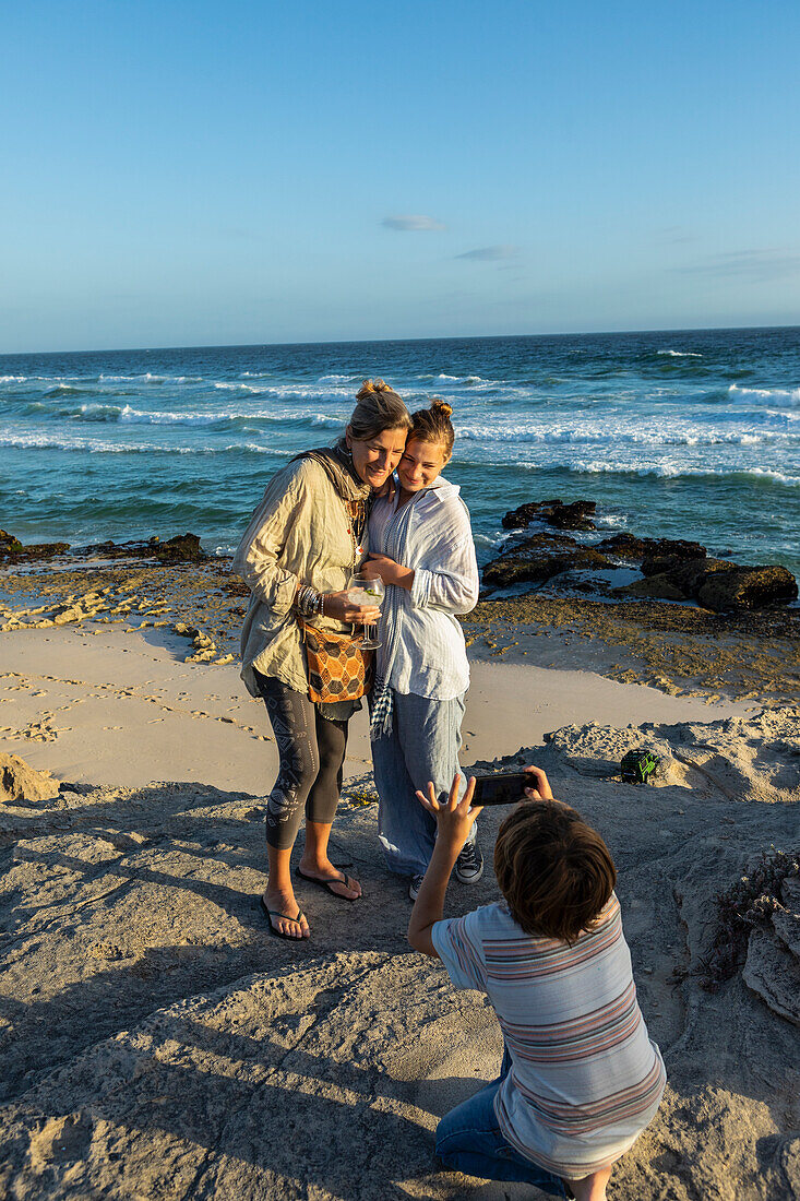 Südafrika, Westkap, Mutter mit Junge (8-9) und Mädchen (16-17) beim Fotografieren am Strand
