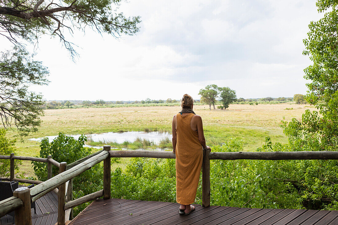 Africa, Northern Namibia, Woman on wooden walkway in Nambwa River Lodge