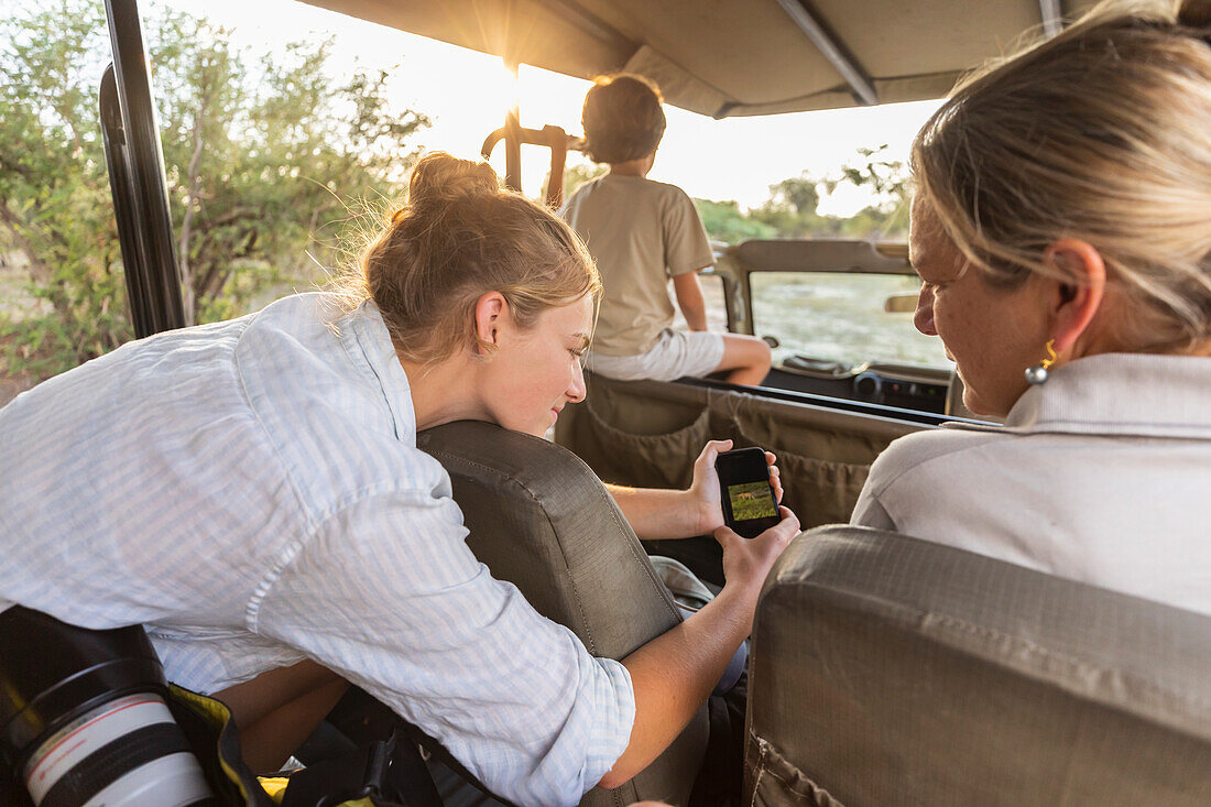 Afrika, Namibia, Frau mit Sohn (8-9) und Tochter (16-17) im Safarifahrzeug