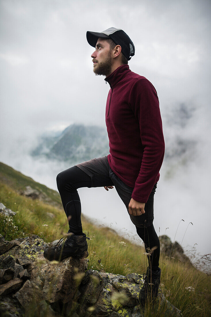 Switzerland, Appenzell, Young man hiking in Swiss Alps