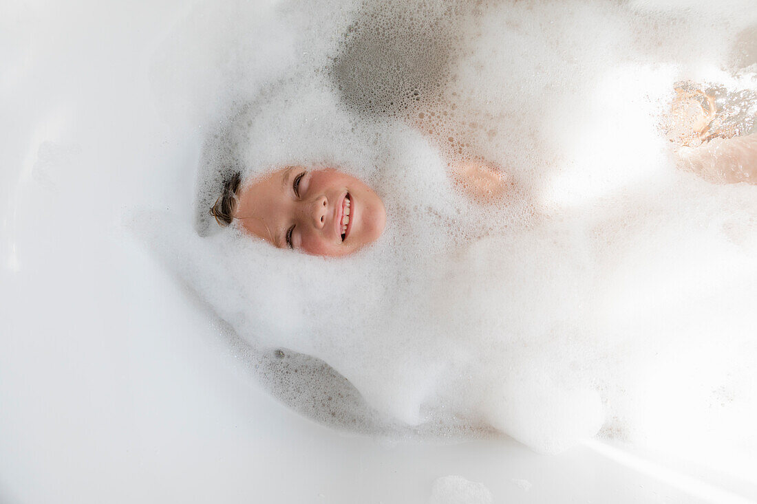 Boy (8-9) in bubble bath