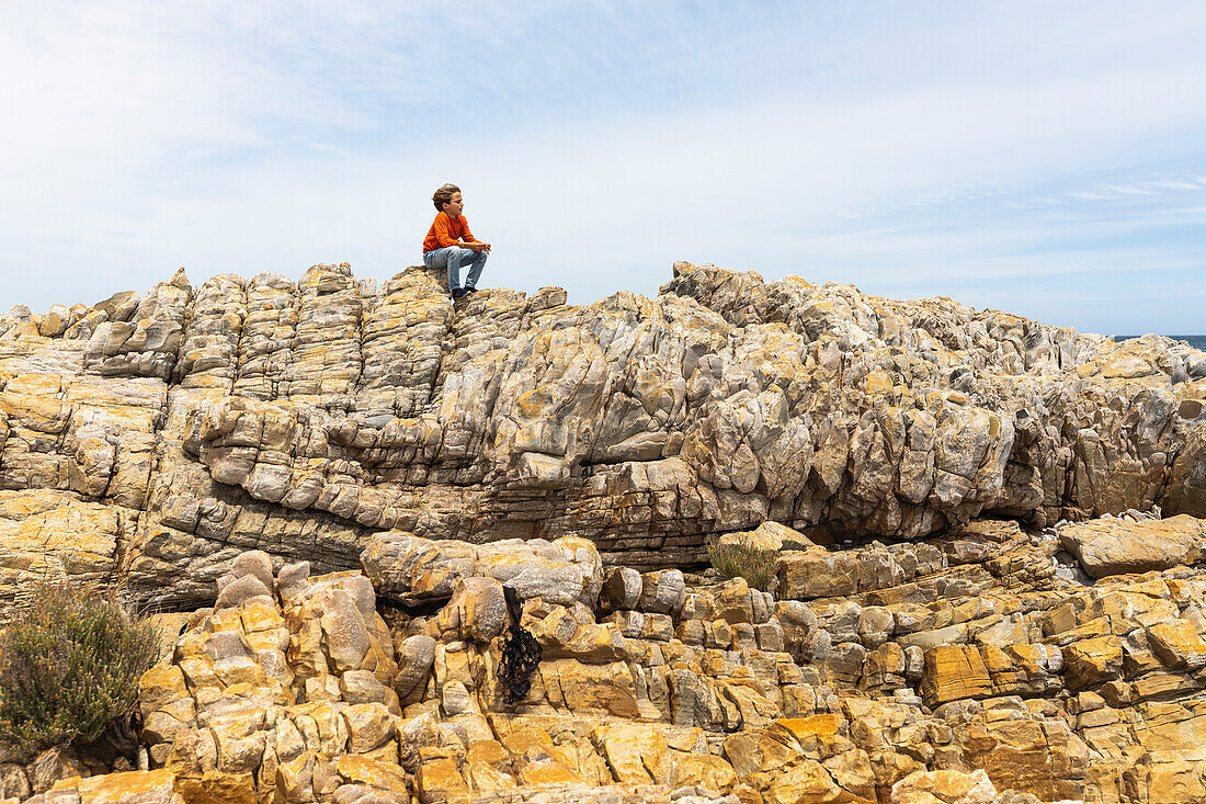 South Africa, Hermanus, Boy (8-9) exploring rocks on Sandbaai Beach
