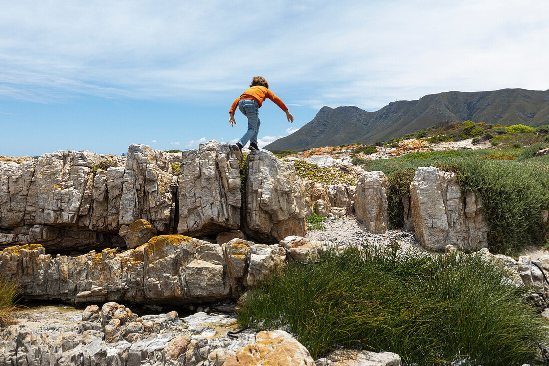 South Africa, Hermanus, Boy (8-9) exploring rocks on Sandbaai Beach