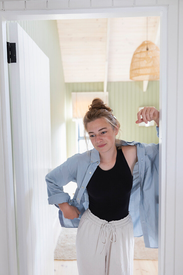 Teenage girl (16-17) standing in doorway