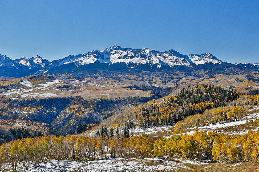 Dallas Mountain and San Juan Mountain Range, Colorado, Autumn colors and aspens glowing gold with wooden fence line