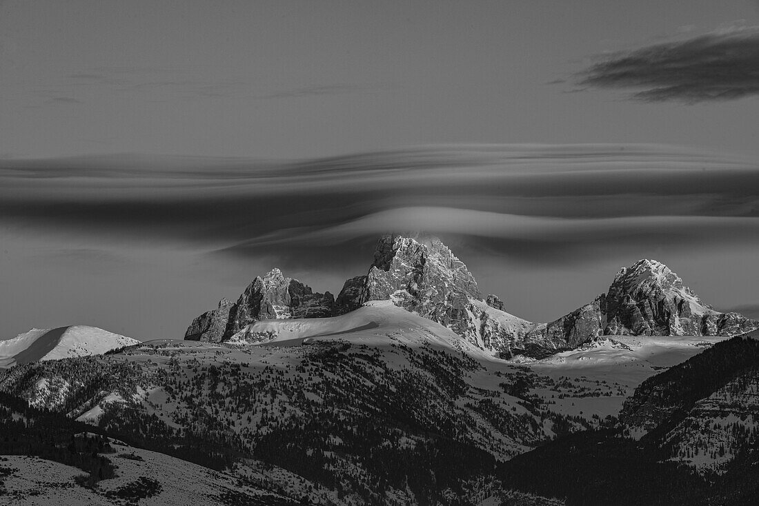 Black and white of Grand Teton, Middle Teton and Mount Owen with cirrus cloud seen from the west.