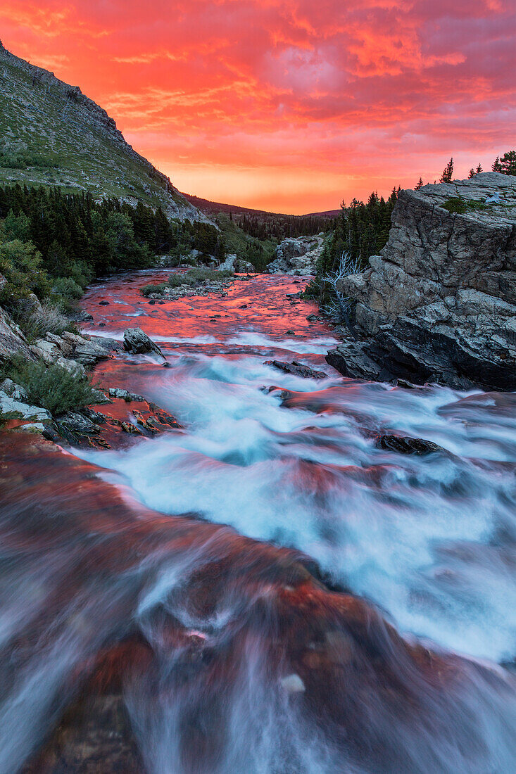 Strahlender Sonnenaufgang über den Swiftcurrent Falls im Glacier National Park, Montana, USA (Großformat verfügbar)