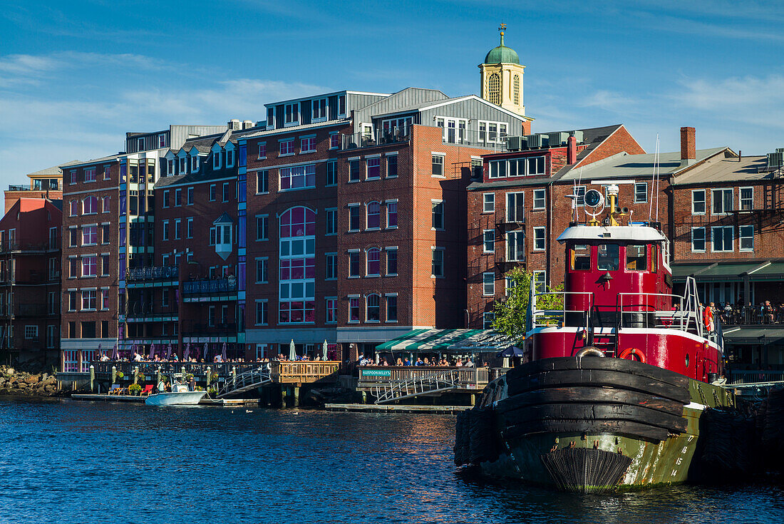 USA, New Hampshire, Portsmouth, waterfront buildings with tugboat