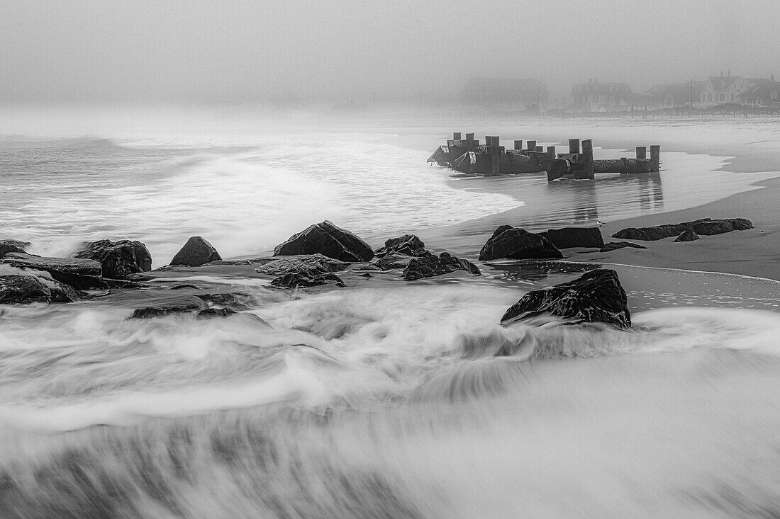 USA, New Jersey, Cape May National Seashore. Black and white of beach waves and old pier