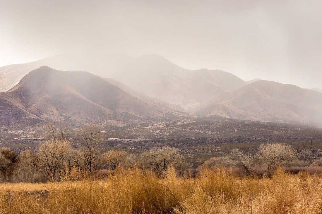 USA, New Mexico, Bosque del Apache National Wildlife Refuge. Storm over mountains and valley