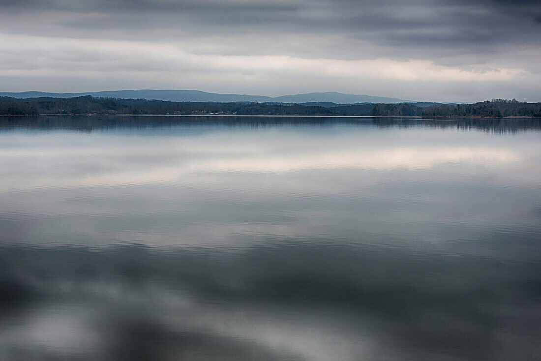 USA, Tennessee. Watts Bar Lake. Glass calm reflects cloud patterns. Appalachian Mountains in distance