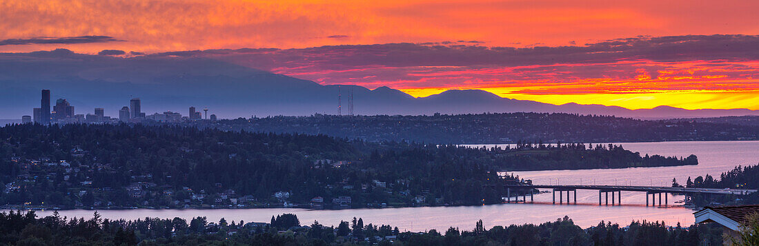 USA, Bundesstaat Washington. Der Washingtoner See, Mercer Island, die Skyline von Seattle und das Olympische Gebirge von Bellevue aus gesehen bei Sonnenuntergang.