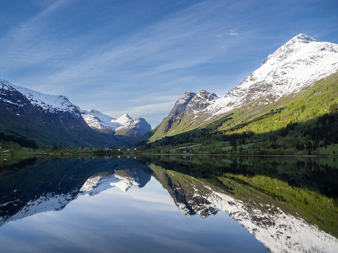 A view of snow-covered mountains and reflections in Lake Oldevatnet, within the Oldedalen River Valley, Vestland, Norway, Scandinavia, Europe