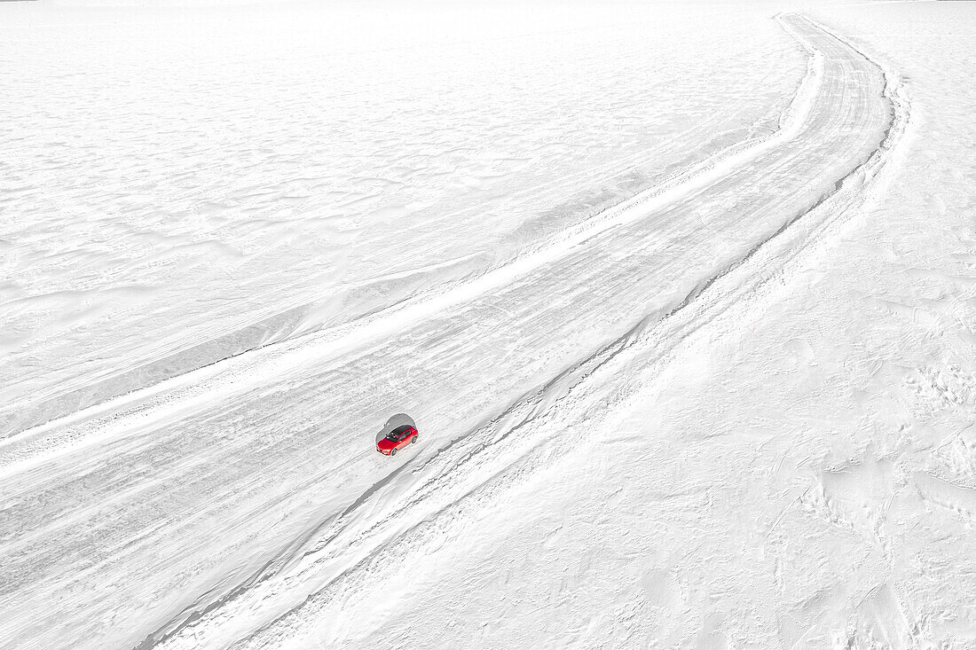 Aerial view of car traveling on empty ice road on the frozen sea, Lulea, Norrbotten County, Lapland, Sweden, Scandinavia, Europe