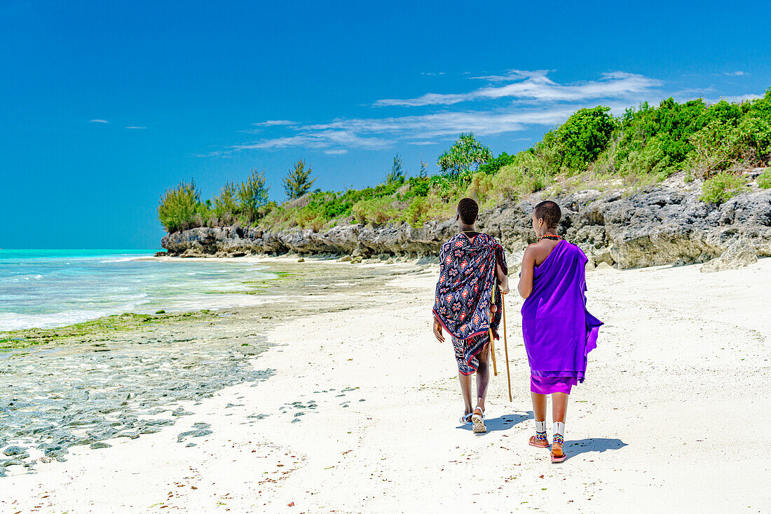 Beautiful Maasai woman with man walking on empty beach, Zanzibar, Tanzania, East Africa, Africa