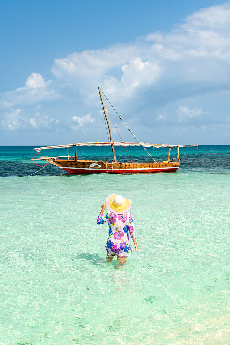 Frau beim Sonnenbad im kristallklaren türkisfarbenen Meer, Kwale Island, Sansibar, Tansania, Afrika, Ostafrika, Afrika