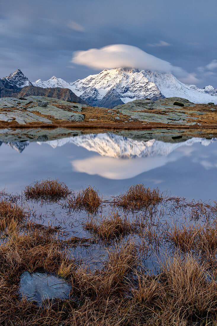 Schneebedeckte Gipfel spiegeln sich in einem Teich im Herbst, Alpe Fora, Valmalenco, Valtellina, Provinz Sondrio, Lombardei, Italien, Europa