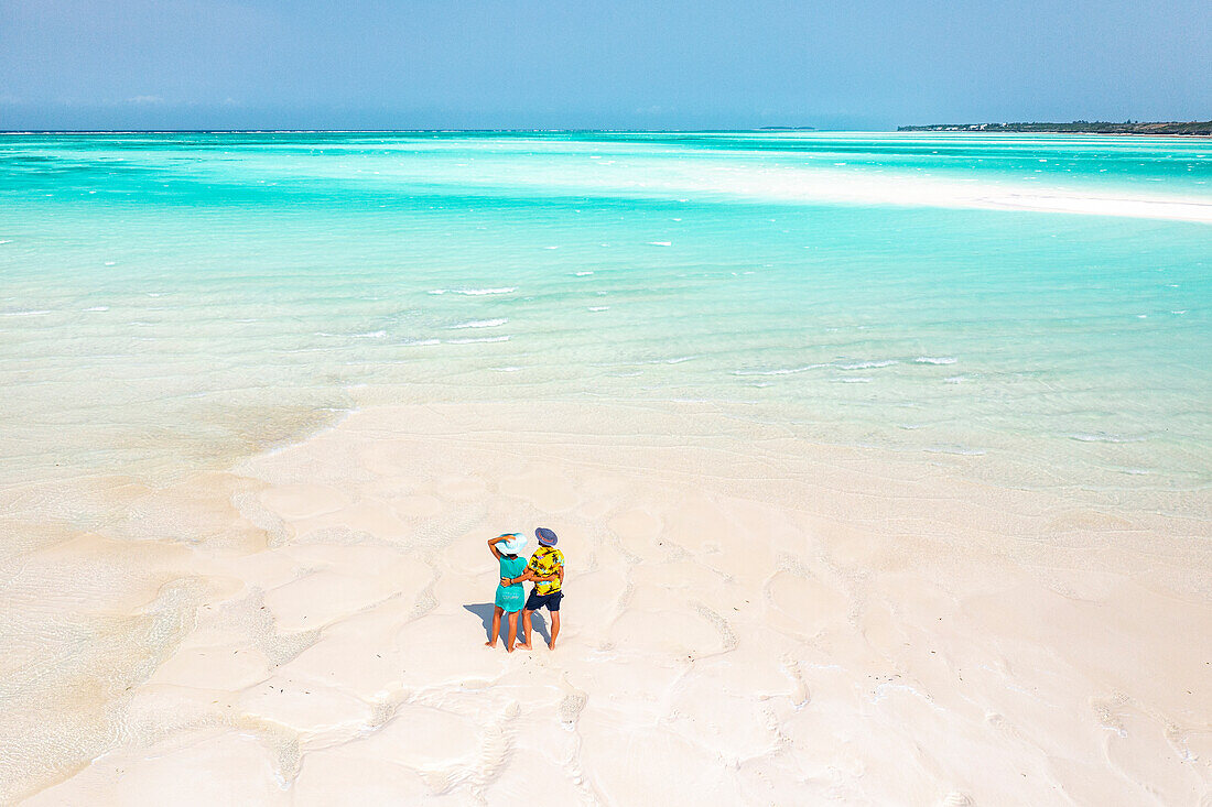 Cheerful man and woman embracing on idyllic tropical beach, overhead view, Nungwi, Zanzibar, Tanzania, East Africa, Africa