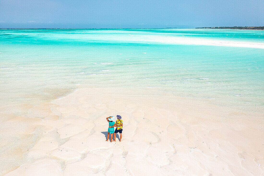 Fröhlicher Mann und Frau umarmen sich an einem idyllischen tropischen Strand, Blick von oben, Nungwi, Sansibar, Tansania, Ostafrika, Afrika