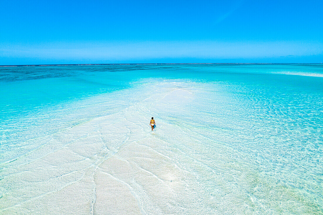 Aerial view of woman bathing in the transparent sea in the scenic sandbanks, Nungwi, Zanzibar, Tanzania, East Africa, Africa