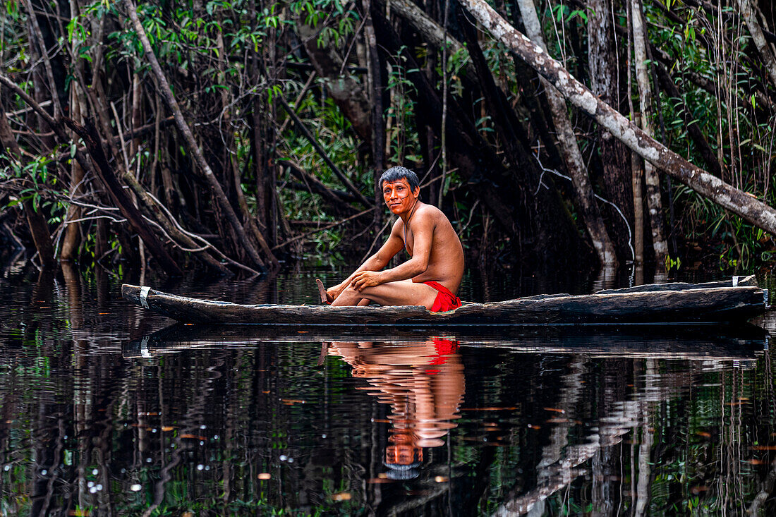 Yanomami-Junge sitzt in einem Kanu auf dem Rio Negro, im Süden Venezuelas, Südamerika
