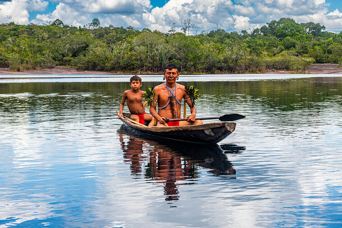 Vater und Sohn vom Stamm der Yanomami in einem Kanu, Südvenezuela, Südamerika