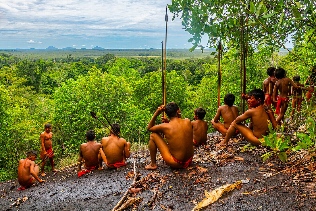 Yanomami tribe sitting on a giant rock in the jungle, southern Venezuela, South America