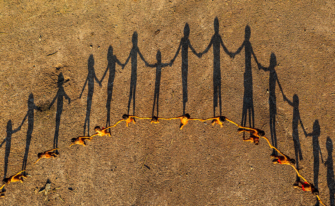 Yanomami-Kinder, die sich in einer Reihe aufstellen und einen Kreis bilden, und Schatten, Yanomami-Stamm, Südvenezuela, Südamerika