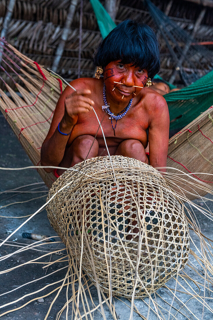Eine Frau vom Stamm der Yanomami flechtet einen Korb, Südvenezuela, Südamerika